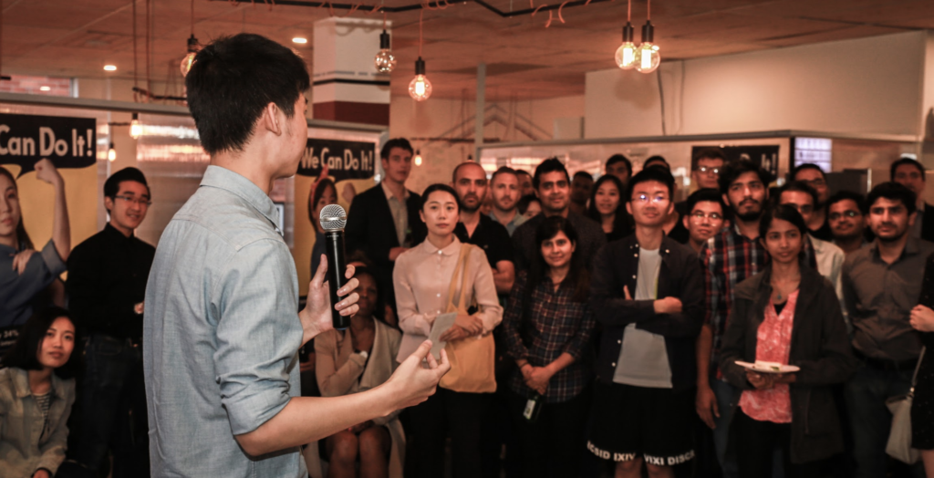 A man giving a speech to a group of international students