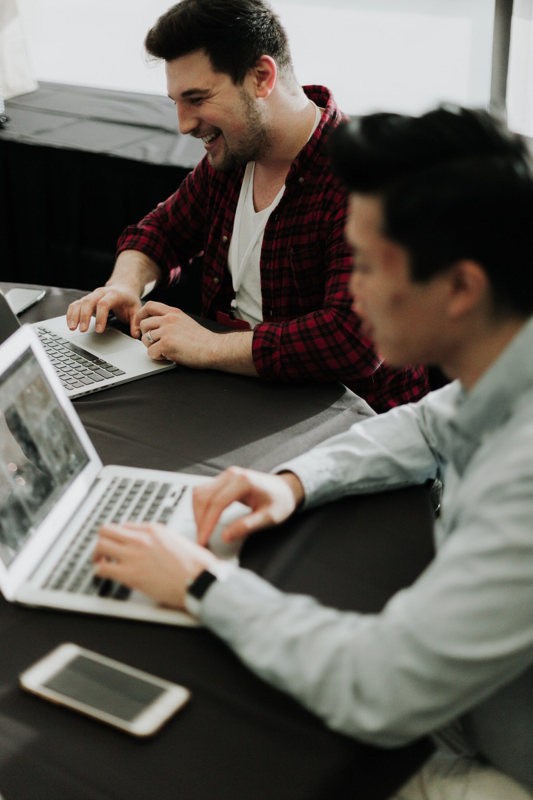 Two students on their laptops in a co-working space. Two students on their laptops in a co-working space.
