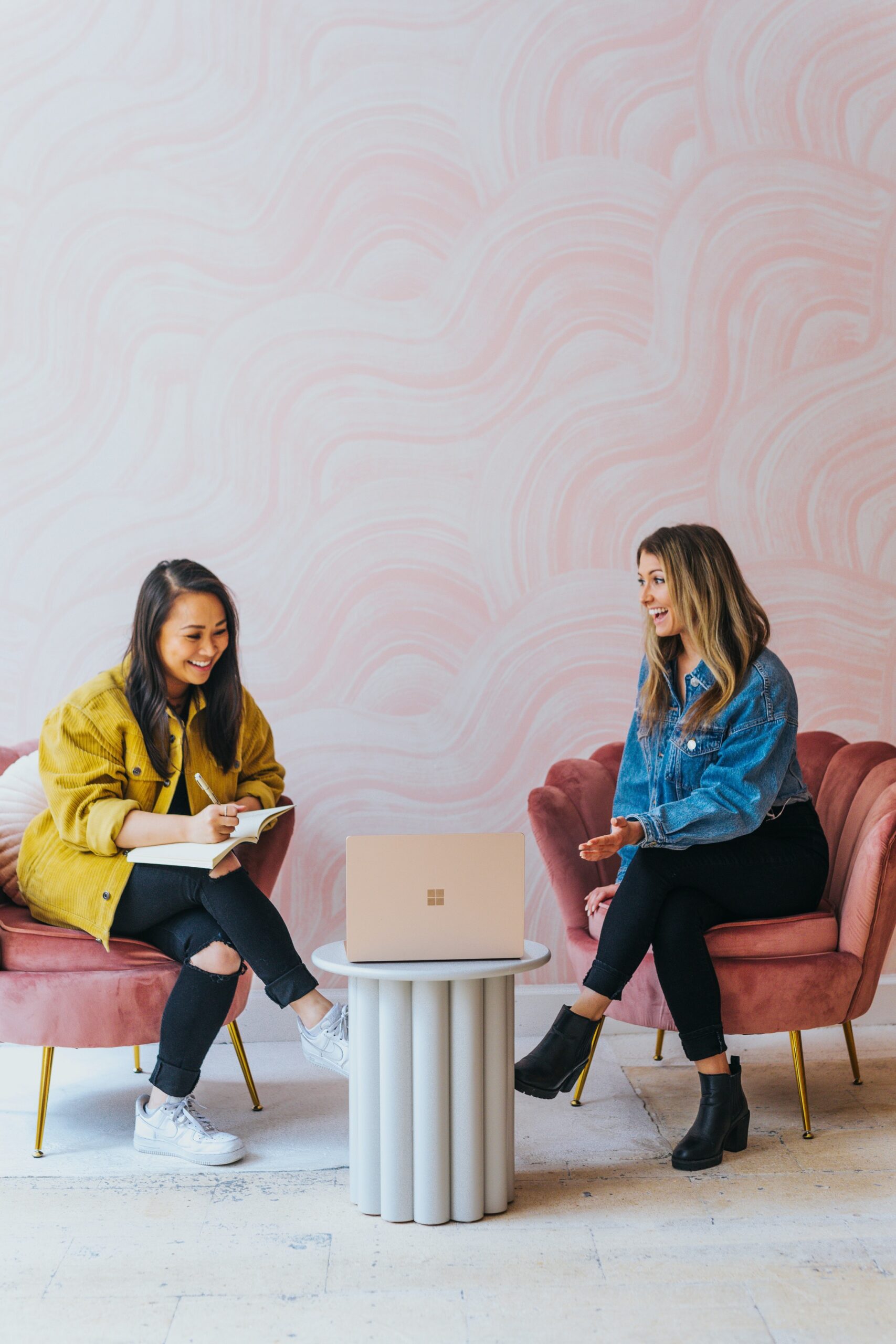 An international intern and her manager sit on chairs. An international intern and her manager sit on chairs.